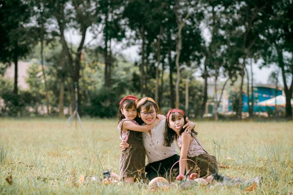 happy asian mother with children in park